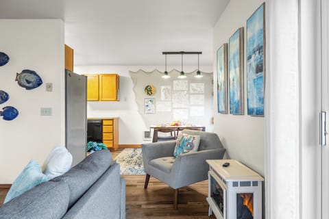 Wide view of the open-concept living and dining space with gray furniture and overhead lighting.