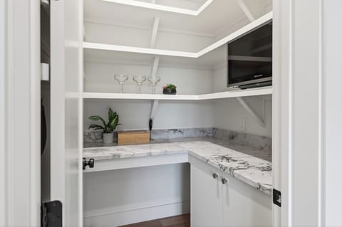 Walk-in pantry with marble counters and extra storage.