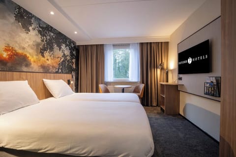 Unwind in crisp linens with calming forest-view window.