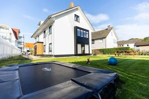 Let the kids play while you relax! This spacious private garden includes a sunken trampoline, toys, picnic benches, and lush green space - perfect for family beach breaks.