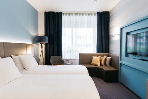 Settle into crisp linens beside a sunlit window lounge.