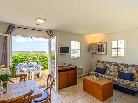 Bright living room with sea views — the sofa bed pulls out for extra guests, and the terrace is just steps away