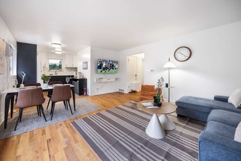 Open living space with TV and seamless flow between kitchen, dining, and lounge.