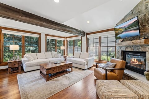 Spacious and well lit living room with smart TV and cozy fireplace