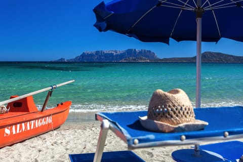 On the beach, white sand, sun loungers, beach umbrellas