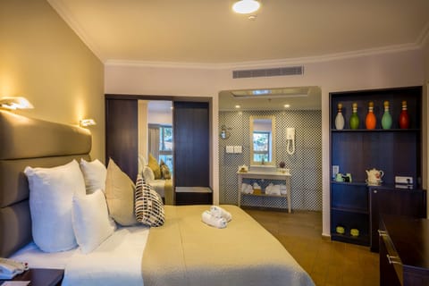 Suite, Garden View | Minibar, in-room safe, desk, laptop workspace