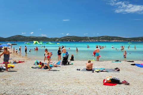 On the beach, white sand, sun loungers, beach umbrellas