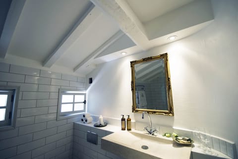 Deluxe Suite | Bathroom | Designer toiletries, hair dryer, slippers, towels