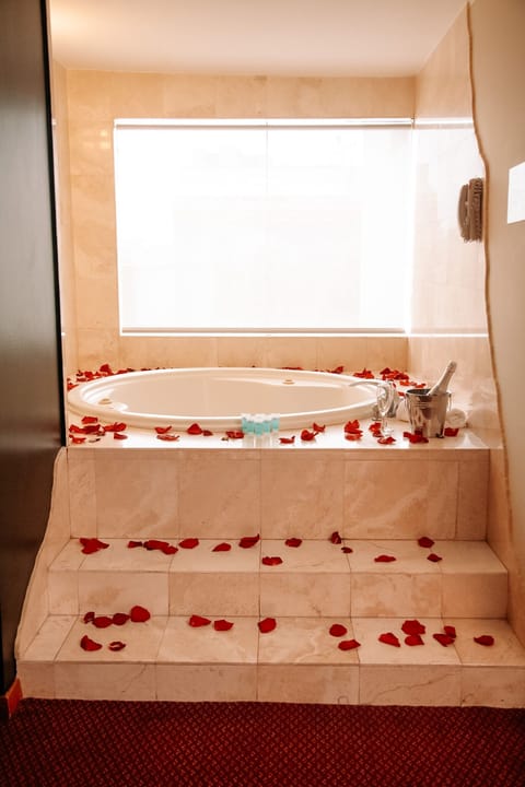 Deluxe Suite, 1 Queen Bed | Bathroom | Combined shower/tub, hair dryer, towels