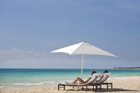 On the beach, white sand, sun loungers, beach umbrellas