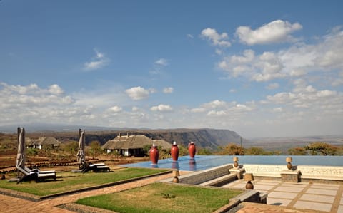 Outdoor pool, an infinity pool, pool umbrellas, sun loungers