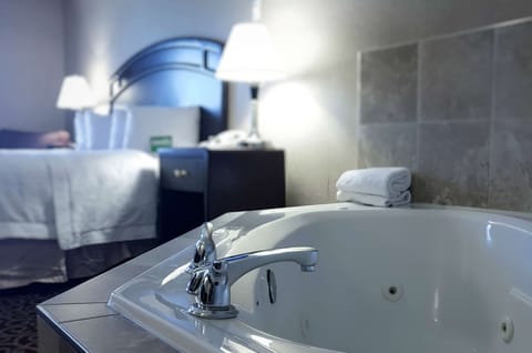 Jacuzzi Suite with 1 King Bed | Bathroom | Bathtub, hair dryer, towels