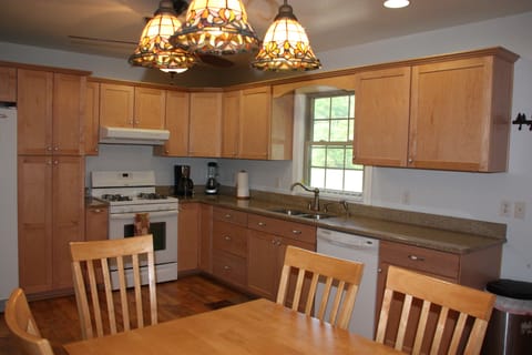Coffee maker, blender, and the microwave stored in the door cabinet.
