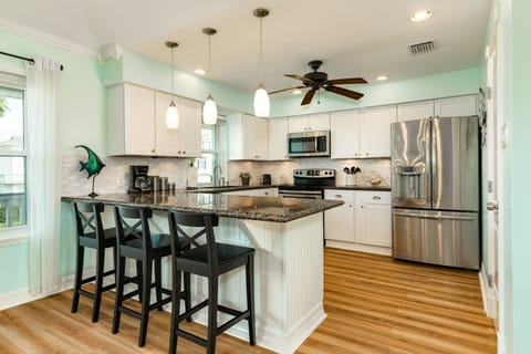 Fully stocked kitchen with granite counter-tops and stainless appliances.