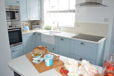 Light and airy open plan modern kitchen with granite worktops and a Belfast sink