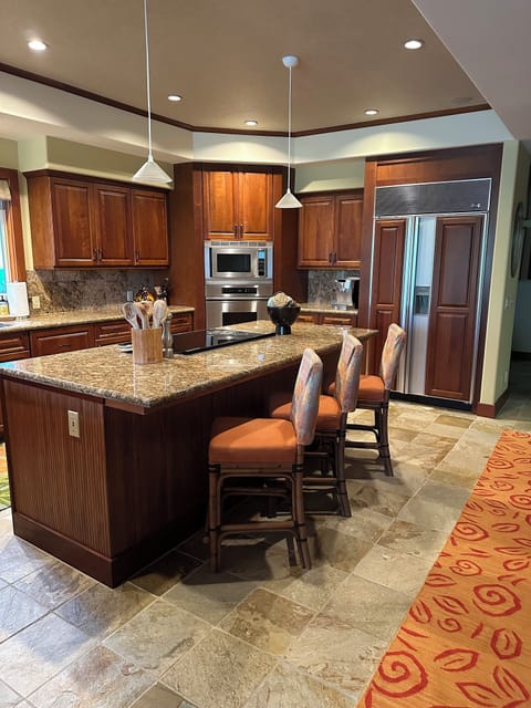 Large spacious kitchen with gourmet cooking appliances, dishes and serving.