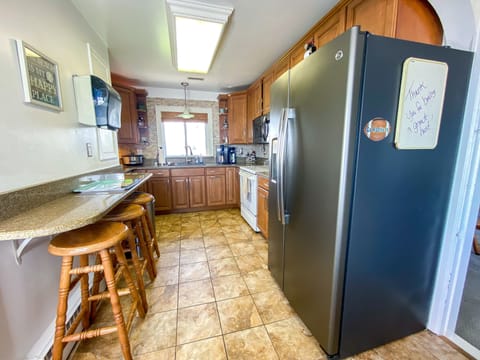 Kitchen has stainless appliances, 3 bar stools, microwave, stove, dishwasher