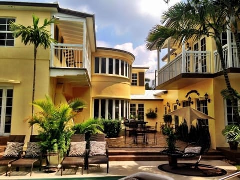 View of back patio w/couches, tables, lounges, swings, chairs in yard & on dock.
