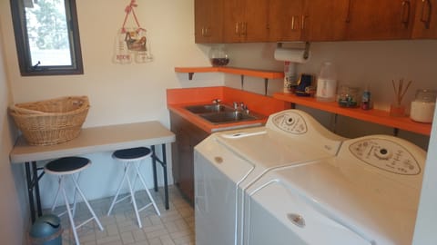 Utility room - Washer, dryer folding table, laundry detergent is provided.
