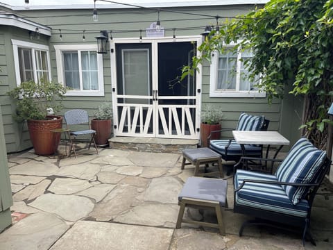 Sunny private courtyard with club chairs. Cafe dining set. Weber grill.