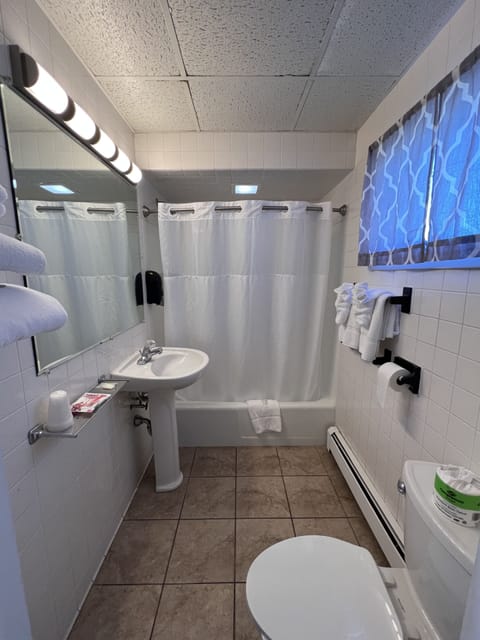 Basic Single Room, 1 King Bed | Bathroom | Combined shower/tub, hair dryer, towels