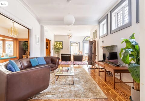 First floor living room with leather couch, smart cable TV, and Alexa speaker.