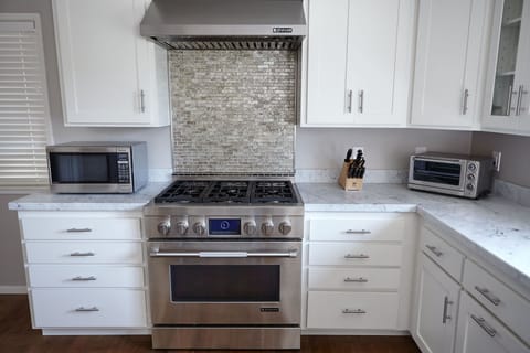 Chef's kitchen with modern appliances and marble countertops
