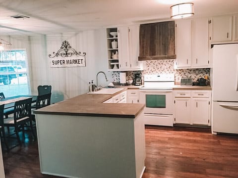 Kitchen stocked w/ a variety of utensils, pots/pans, dishes, and lots of extras