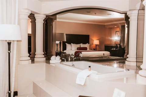 Deluxe Jacuzzi Suite | In-room safe, desk, blackout drapes, iron/ironing board