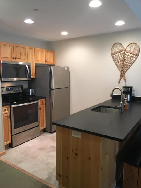 Kitchen with stainless steel appliances & updated leathered granite countertops.