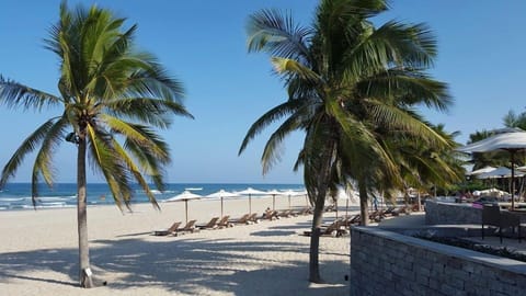 On the beach, white sand, sun loungers, beach umbrellas