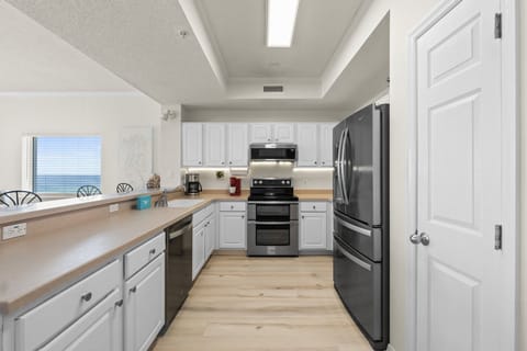 Kitchen - The kitchen is well stocked and includes stainless steel appliances. Notice there is plenty of counter space for preparing your favorite meals.