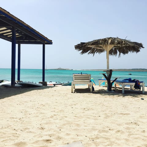 On the beach, white sand, beach cabanas, sun loungers