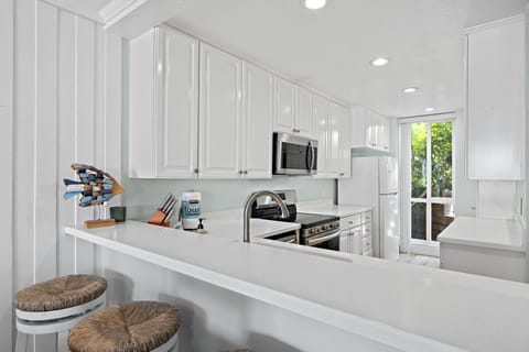 Fully stocked kitchen with bar seating, perfect for breakfast or evening snacks