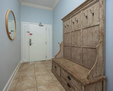 Welcoming entryway featuring a rustic bench, light blue walls, and a round mirror for a cozy ambiance