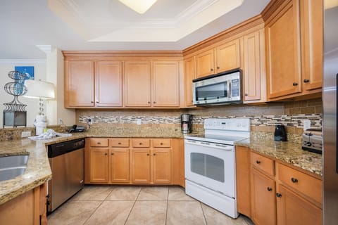 Enjoy the inviting ambiance of this modern kitchen featuring granite countertops and white and stainless steel appliances