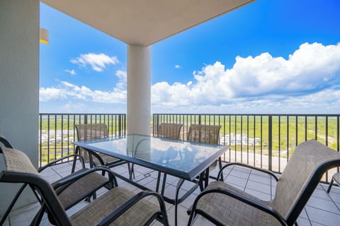 Enjoy stunning area views from this spacious balcony with a glass table and comfortable seating