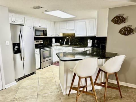 There are two more spots at the bar! This fully stocked kitchen with stainless appliances has everything you need!