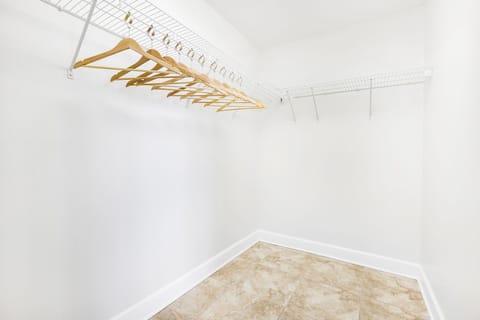 This spacious master closet features organized shelving and wooden hangers for convenient storage of your belongings