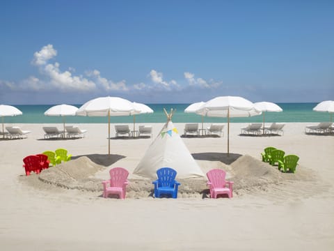 On the beach, white sand, beach cabanas, sun loungers