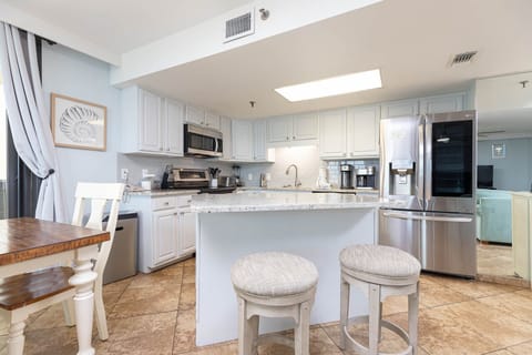 Bright kitchen featuring white cabinetry, granite countertops, and a breakfast bar, complemented by the dining area