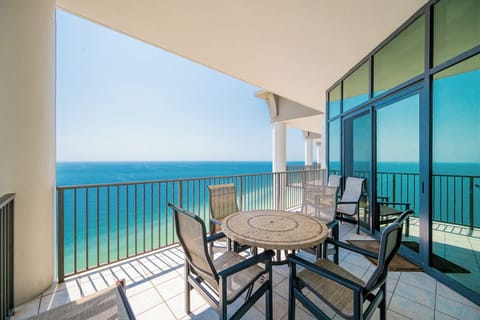 Relax on the spacious balcony with stunning views of turquoise waters and comfortable seating for unforgettable moments