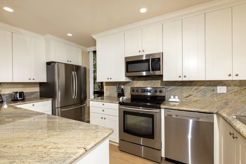 Kitchen - The stunning kitchen has slab granite counters and stainless appliances.