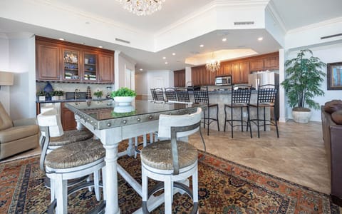 This elegant kitchen features rich wood cabinetry, stainless appliances, and a stylish dining area perfect for gatherings