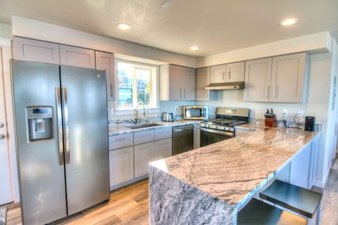 Stunning granite counter top peninsula with waterfall finish offers seating for 4.