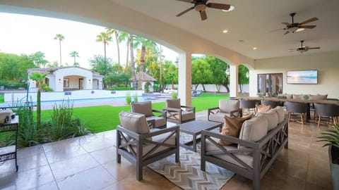 Spacious covered patio with comfy seating, dining, and beautiful pool views.