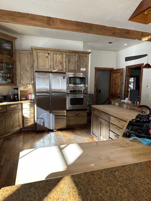 A large kitchen with knotty alder cabinets, granite and wood countertops.