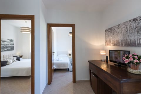 Deluxe Quadruple Room, 2 Bedrooms | Minibar, desk, laptop workspace, iron/ironing board