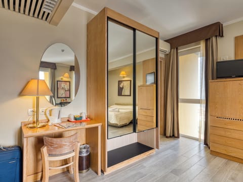 Economy Quadruple Room | Minibar, in-room safe, desk, bed sheets