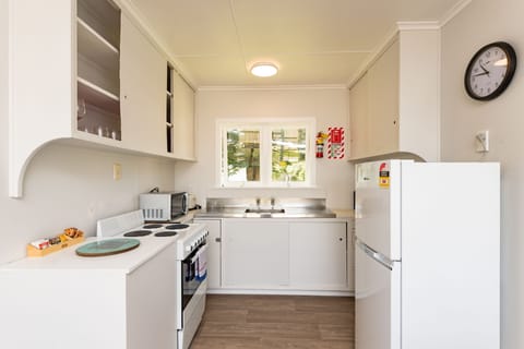 Waitangi Beach Bach 30B | Private kitchen | Full-size fridge, microwave, oven, stovetop